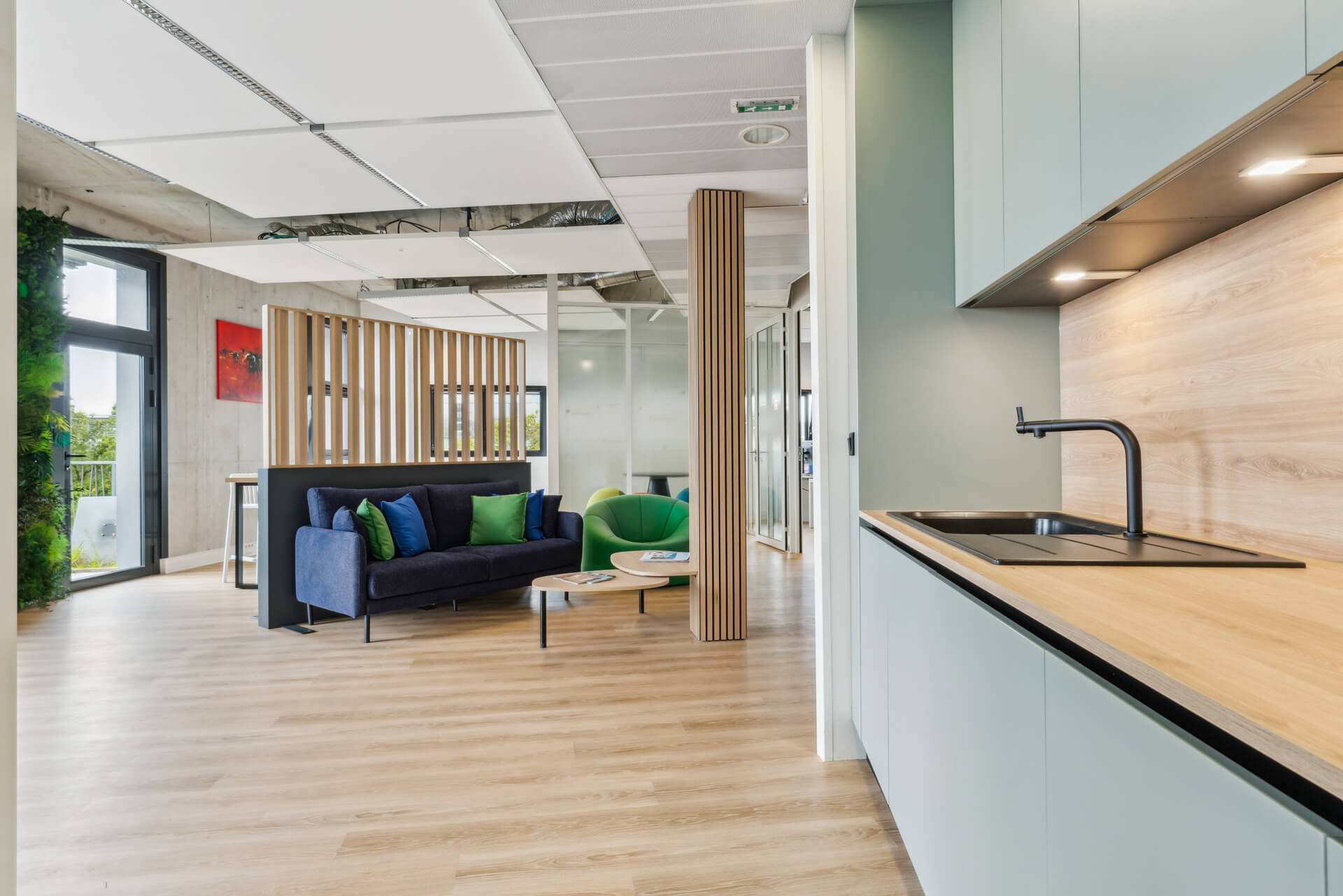 Vue du nouvel espace d'accueil et nouvelle cuisine des bureaux Sofira rénovés par WENES Aménagement